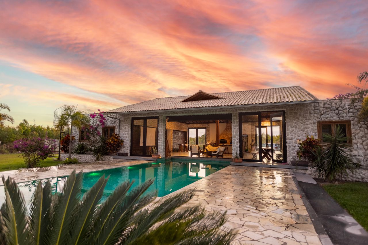 gallery-3 Beautiful stone villa with pool and vibrant sunset sky, perfect for luxury travel.